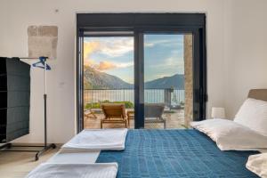 een slaapkamer met een bed en een glazen schuifdeur bij Beachfront Villa Nautica in Kotor