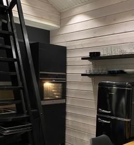 a small kitchen with a stove and a refrigerator at Norvamaja with a lake view, sauna and jacuzzi in Rovaniemi +19 photos
