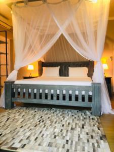a bedroom with a large bed with a canopy at Naara Eco Lodge & Spa in Chidenguele