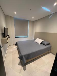 1 dormitorio con 1 cama y TV en Departamento de 1 habitación - Excelente ubicación- Villa Morra Asuncion #303, en Asunción