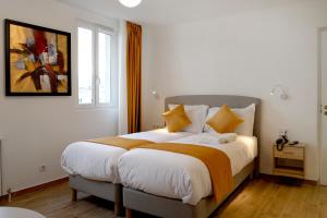 - une chambre avec un grand lit et des oreillers jaunes dans l'établissement Les Rebelles, à Paris