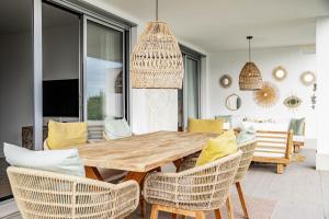 een eetkamer met een houten tafel en stoelen bij LM10BB- Modern ground floor flat in Le Mirage in Estepona