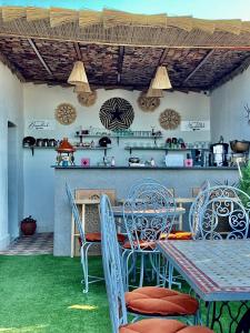 eine Terrasse mit einem Tisch und Stühlen sowie eine Küche in der Unterkunft Winarouze house in Marrakesch