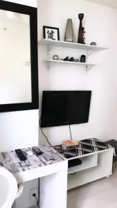 a living room with a tv on a white wall at Apartamento Duvivier in Rio de Janeiro