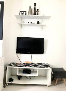 un centro di intrattenimento bianco con TV a schermo piatto di Apartamento Duvivier a Rio de Janeiro