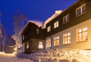 ein schneebedecktes Gebäude in der Nacht in der Unterkunft Bürger- und Berggasthaus Scheibenberg in Scheibenberg