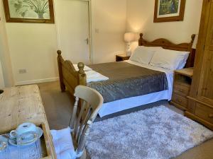 a bedroom with a bed and a table and a chair at The Crown & Victoria Inn in Tintinhull