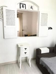 a room with a mirror and a bed and a table at Apartamento Duvivier in Rio de Janeiro