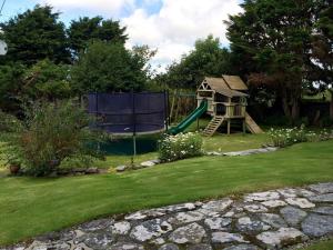 a playground with a slide in a yard at Courtyard Farm Cottages in Boscastle