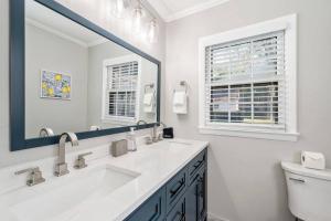 a white bathroom with a sink and a mirror at Private 1BR Cottage In Downtown Historic Norcross in Norcross