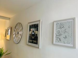 two framed pictures and a clock on a wall at Salisbury Solace in Salisbury