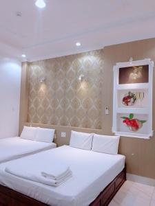 um quarto com 2 camas e uma parede com prateleiras em HOTEL SAO MAI địa chỉ 22D3 TRẦN QUANG KHẢI em Can Tho