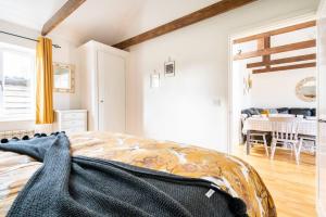 New Listing - Idyllic cottage in a beautiful Kent setting في Kent: غرفة نوم مع سرير وغرفة طعام