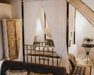 a bedroom with a black canopy bed with curtains at Apanemia Inn Studio in Lofou