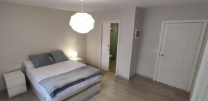 um quarto branco com uma cama e um candeeiro em The Urban Flat Vigo em Vigo