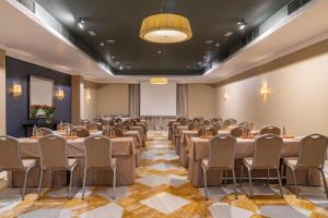 a conference room with tables and chairs and a projection screen at Vincci Albayzin in Granada