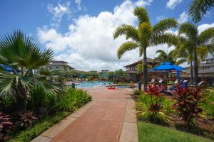 una piscina en un complejo con palmeras en Pili Mai II, en Koloa