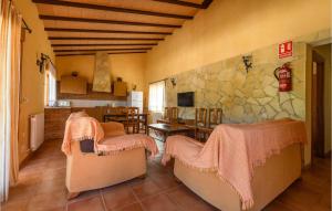 sala de estar con 2 sillas y pared de piedra en Beautiful Home In Caravaca De La Cruz With Outdoor Swimming Pool And 3 Bedrooms en Caravaca de la Cruz