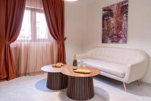 a living room with a white couch and a table at Cappo suites in Veliko Tŭrnovo