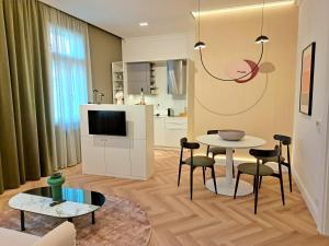 een woonkamer met een tafel en stoelen en een televisie bij Hotel Domus Collis in Győr