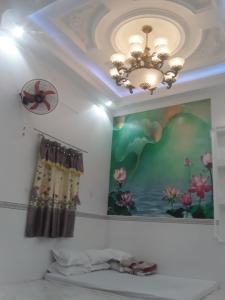 um quarto com um tecto com uma pintura e um lustre em HOTEL SAO MAI địa chỉ 22D3 TRẦN QUANG KHẢI em Can Tho