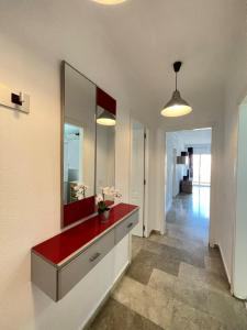 een badkamer met een rode wastafel en een spiegel bij LaFrenchTouch - Torrequebrada 2dorm cerca playa in Benalmádena