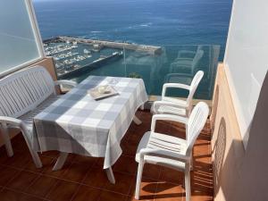 a balcony with a table and chairs and the ocean at Los Gigantes in front of Sea in Acantilado de los Gigantes