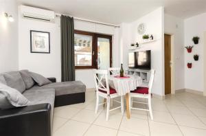 een woonkamer met een bank en een tafel met stoelen bij Apartment Mare in Srima
