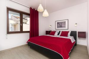 a bedroom with a red bed and a window at Apartment Mare in Srima