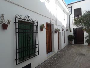 a white building with a gate and a door at Vivienda Turística de Alojamiento Rural "EL PATIO" in Priego de Córdoba