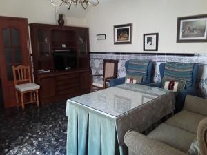 ein Wohnzimmer mit einem Sofa und einem Tisch in der Unterkunft Vivienda Turística de Alojamiento Rural "EL PATIO" in Priego de Córdoba