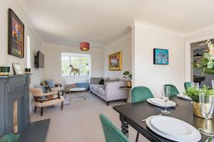 a living room with a table and green chairs at St George's - stylish family home in Sandwich in Kent