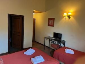 a room with two beds and a desk with a computer at Hotel Campanilla in Ushuaia