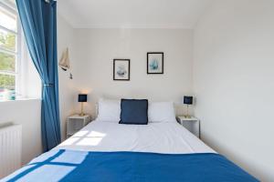 a bedroom with a large bed with blue and white sheets at St George's - stylish family home in Sandwich in Kent