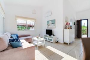 a living room with a couch and a tv at Bungalow Mikaella by Ezoria Villas in Coral Bay +51 photos