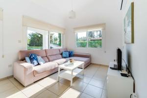 a living room with a couch and a table at Bungalow Mikaella by Ezoria Villas in Coral Bay