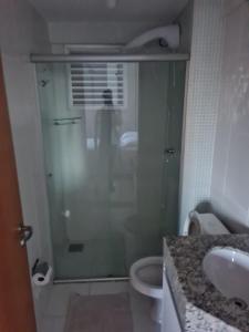 een badkamer met een douche, een toilet en een wastafel bij Apartamento próximo ao shopping pantanal in Cuiabá