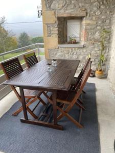 a wooden table and chairs on a balcony at Studio dans ferme en rénovation in Touille +14 photos