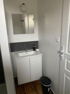 a white bathroom with a sink and a mirror at Studio dans ferme en rénovation in Touille