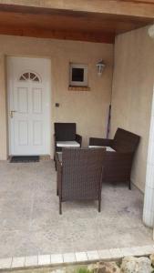 un patio con 2 sillas y una puerta blanca en Près d'Evry, petite maison indépendante 1 ch 1 terrasse, en Lisses
