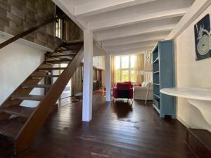 - un salon avec un escalier dans une maison dans l'établissement La Saucisserie Gites, à Saint-Pierre-de-Frugie