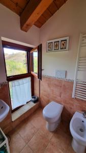 baño con aseo y lavabo y ventana en Il Casale di Giovanna, en Offida