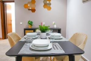 - une table à manger avec des assiettes blanches et de l'argenterie dans l'établissement YourPlace - 2BR - Agdal - Av France, à Rabat