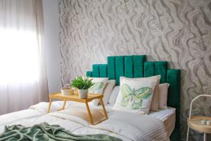 - un lit avec des oreillers verts et blancs et une table dans l'établissement YourPlace - 2BR - Agdal - Av France, à Rabat