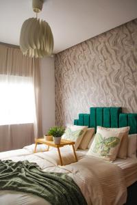 拉巴特的住宿－YourPlace - 2BR - Agdal - Av France，一间卧室配有一张大床和绿色床头板