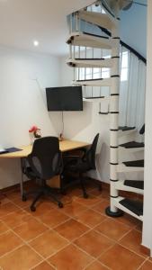 an office with a desk and chairs and a spiral ladder at Près d'Evry, petite maison indépendante 1 ch 1 terrasse in Lisses