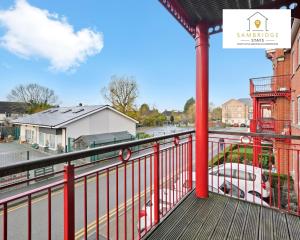 a balcony with a red railing and a street at Beautiful 2 Bedroom Seviced Apt in Aylesbury By Sambridge Stays Short Lets & Serviced Accommodation in Aylesbury