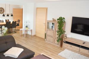 a living room with a couch and a flat screen tv at Ferienwohnung am Waldweg in Kolsass