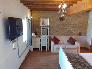 a bedroom with a living room with a couch and a table at The Byre North End Farm in Ashton Keynes