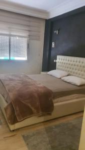 a bedroom with a large bed and a window at Résidence les champs N3 in Casablanca